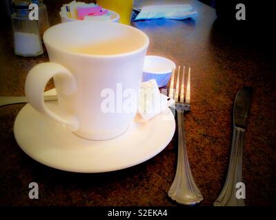 Bianco tazza di caffè sul tavolo da pranzo con pacchetti di Stevia Foto Stock