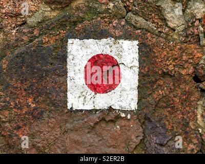 Escursionismo simbolo di marcatore in corrispondenza di una cava di pietra sulla parete di un sentiero escursionistico in Germania, quadrato bianco con un punto rosso al centro Foto Stock