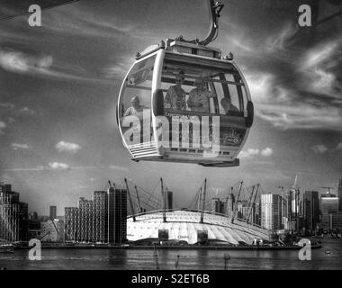 Un Emirates Air Line Funivia passa sopra il fiume Tamigi e l'O2 Arena di Londra, Inghilterra. È avveniristico o semplicemente un normale modo di viaggiare per lavoro? Foto © COLIN HOSKINS. Foto Stock