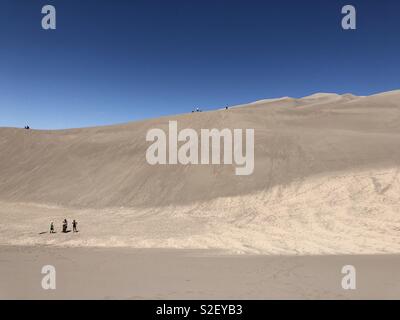 I visitatori di grandi dune di sabbia del Parco Nazionale in Colorado escursione attraverso le grandi dune di sabbia negli Stati Uniti. Gli ospiti possono affittare slitte di sabbia e schede di sabbia a scorrere verso il basso le dune fino a 35 km/h. Foto Stock