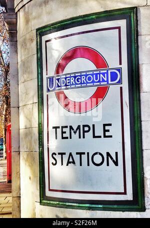 Cool retrò segno della metropolitana al di fuori del tempio stazione sulla riva nord del Tamigi a Londra, con davvero bella verde bordo della piastrella Foto Stock