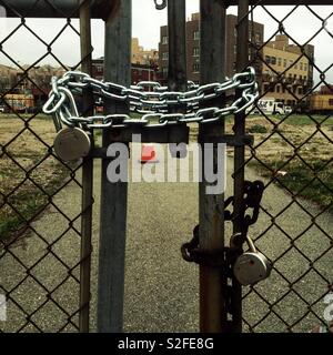 Catene di chiudere le porte di un vuoto molto nel sud Williamsburg, Brooklyn. Sullo sfondo di edifici di alloggiamento dove gli ortodossi Hasidic comunità vive Foto Stock