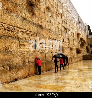 Pregando sotto la pioggia al muro occidentale Foto Stock