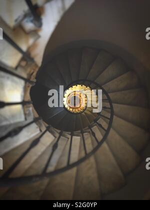 Antica scalinata a spirale con letti in ferro battuto con corrimano e gradini in marmo Foto Stock