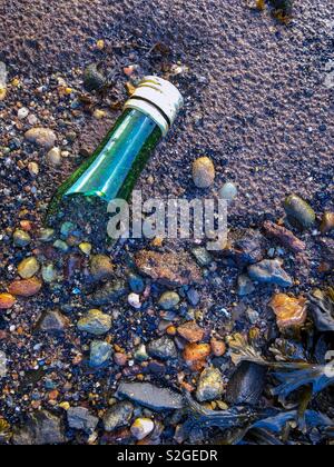 Collo di scartare la bottiglia di vino sulla spiaggia. La Scozia. Regno Unito. Foto Stock