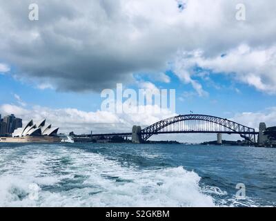 Sydney Harbour Bridge e l'Opera House in un giorno nuvoloso nel porto di Sydney Foto Stock