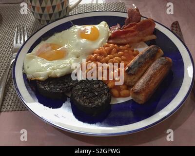 Una completa prima colazione Inglese con uova fritte, fagioli, salsicce. pancetta e black pudding. Foto Stock