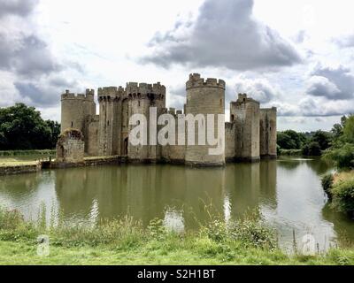 Vista del Castello Bodiam nel Kent attraverso il fossato sotto un cielo nuvoloso Foto Stock