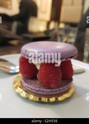 Macaron sandwich riempito con crema chantilly e lamponi al bar Foto Stock