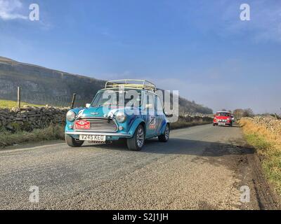 Classico minis su strada in Yorkshire Dales Foto Stock