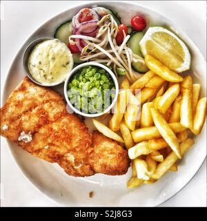 Pesce e patatine con fiacco di piselli e insalata di contorno. Foto Stock