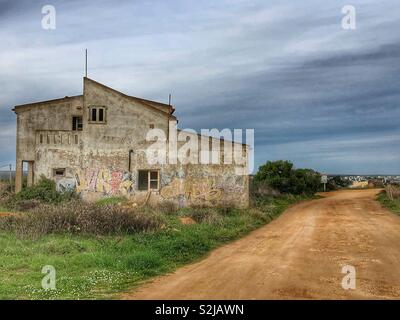 Edificio abbandonato su una pista sterrata Foto Stock