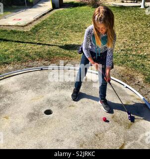 Ragazza che gioca mini golf Foto Stock