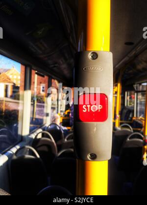 L'interno di un quasi vuoto bus, sottolineando il passeggero-attivato il pulsante di arresto, rosso su un palo di colore giallo. Foto Stock