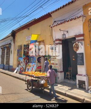 Frutto di un venditore ambulante spingendo il suo carrello giù per una strada nel Getsemani quartiere di Cartagena, Colombia. Foto Stock