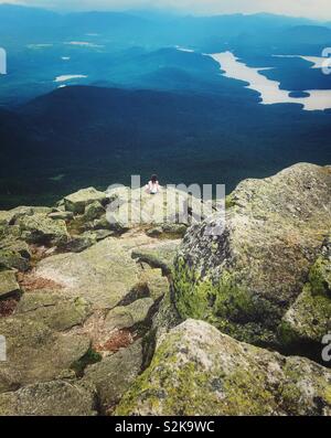 Ragazza guardando alla vista di Lake Placid e Montagne Adirondack dalla parte superiore del Whiteface Mountain in Wilmington, NY, STATI UNITI D'AMERICA Foto Stock