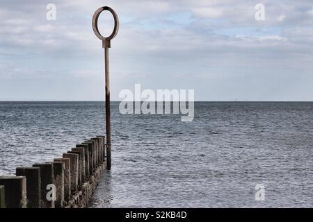 Marcatore post con anello al fine di spiaggia groyne Foto Stock
