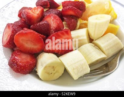 Frutta fresca nella piastra - banana, fragola e fettine di arancia - Dieta sana icona Foto Stock