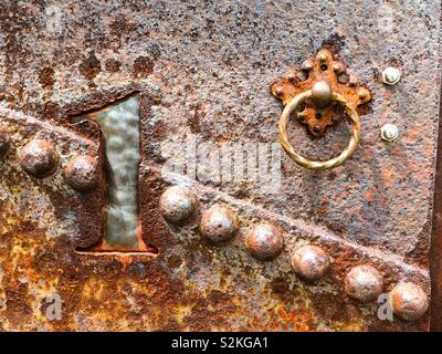 Metallo arrugginito numero uno con anello di trazione sulla cassetta postale. Rivetti di ruggine e steampunk numero. Foto Stock