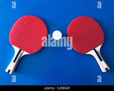 Red ping pong pipistrelli su sfondo blu Foto Stock