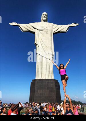 Tenendo in posa a nuove altezze di fronte all'iconico Cristo Redentore statua a Rio de Janeiro in Brasile. Foto Stock