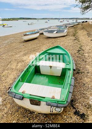 Waldringfield, Suffolk, Regno Unito - 26 Aprile 2019: verde brillante barca sulla spiaggia dal fiume Deben. Foto Stock