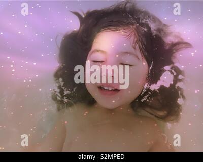 Giovani e carine multi-etnico (vietnamita/Caucasian/Punjabi) ragazza a sognare il cosmo. Foto Stock