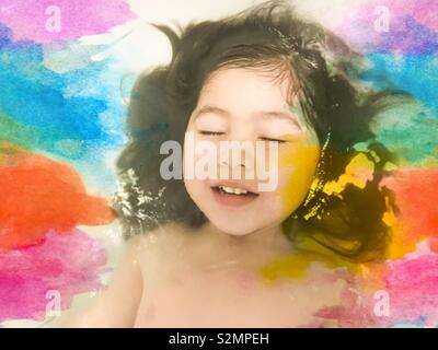 Carino e giovane multi-etnico (vietnamita/Caucasian/Punjabi) ragazza sognare i colori dell'acqua. Foto Stock