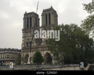 Notre Dame de Paris il 23 aprile 2019, dopo l'incendio ha distrutto la sua guglia e parte del suo tetto, mostrando il nord e il sud campanili, west rosone e un derrick davanti. Foto Stock