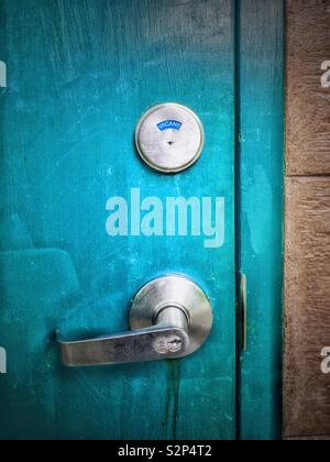 Vivacemente colorato outdoor sbloccato per wc wc in stallo la porta di metallo con la parola "vacante" indicata sul segno di bloccaggio. Foto Stock