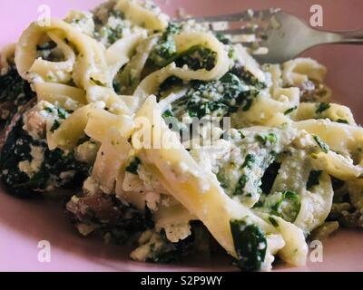 Tagliatelle con ricotta e spinaci servito in una ciotola rosa Foto Stock