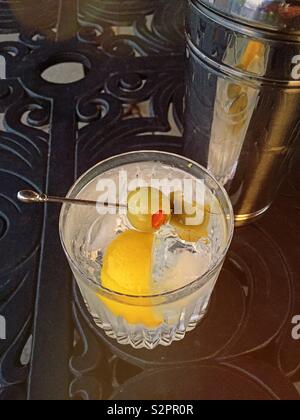 Un martini cocktail sulle rocce in un bicchiere di cristallo accanto a uno shaker su un patio esterno tavolo, STATI UNITI D'AMERICA Foto Stock