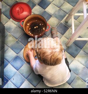 Due anni di vecchio ragazzo di funghi di taglio sul pavimento della cucina. Foto Stock