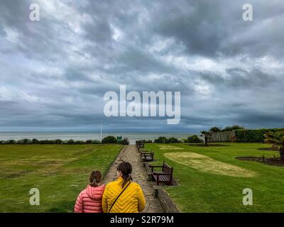 Madre e figlia camminando giù per il lungomare Foto Stock