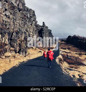 I turisti a piedi nella valle della spaccatura tra Nord America e Eurasian placche tettoniche, Þingvellir ,l'Islanda Foto Stock