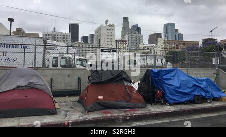 LOS ANGELES, CA, GIU 2019: senzatetto tende sul marciapiede in fiore quartiere di Downtown. Grattacieli in background Foto Stock