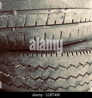 Due vecchie indossato pneumatici per auto impilate una sull'altra, mostrando il battistrada usurato Foto Stock