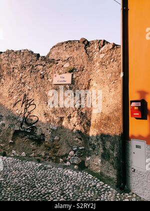 Vecchio muro con graffiti su strada italiano Foto Stock