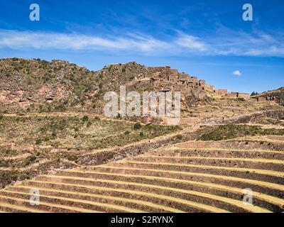 Paesaggio orizzontale formato. Terrazzamenti agricoli terrazzamento di fronte di edifici in rovina di Inca Pisaq Pisac Písac Inca Inca peruviano sito archeologico. Foto Stock