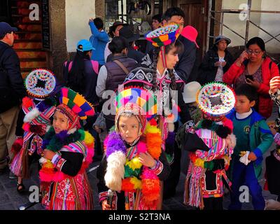 I bambini piccoli nei coloratissimi costumi per loro Inti Raymi'rata o Inti Raymi sun festival parade, uno Inca celebrazione del solstizio d'inverno. Cusco Cuzco Perú Perù. Foto Stock