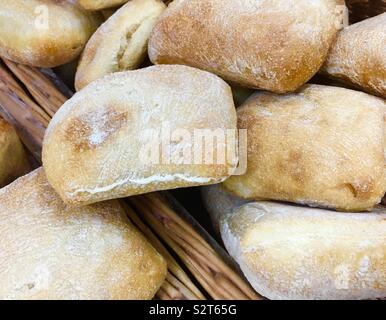 Cesto pieno di pane appena sfornato ciabatta pane sulla vendita in un forno Foto Stock