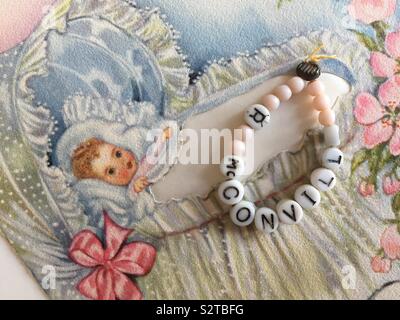 Vintage di perline braccialetto di riconoscimento per un neonato ragazza in un ospedale e vivaio close up di un annuncio scheda, 1940s Foto Stock