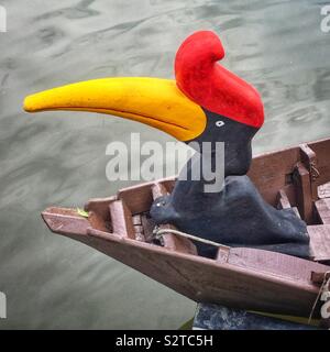 La grafica stilizzata e intagliato di legno verniciato hornbill uccello come polena su un tradizionale Orang Ulu barca utilizzata per le crociere turistiche sul Fiume Sarawak Kuching, Sarawak, Malaysia Foto Stock