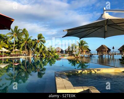 Piscina Infinity, spa e over water bungalows in un resort di Moorea, Polinesia Francese Foto Stock