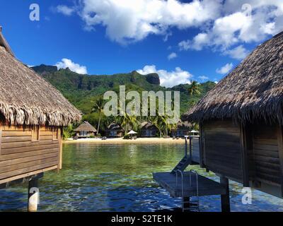 Vista tra due bungalow Overwater di un lussuoso resort sulla spiaggia di Moorea, Polinesia francese come visto dalla laguna Foto Stock