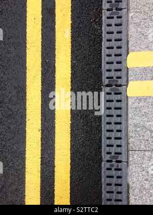Doppie linee di colore giallo sul lato della strada Foto Stock