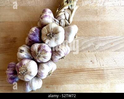 Treccia di aglio su uno sfondo di legno Foto Stock