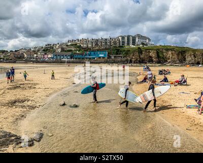 Surfers camminando sulla spiaggia a Perranporth Foto Stock