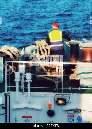 Lavoratore di traghetto sul Caledonian MacBrayne traversata in traghetto il Minch da Tarbert a Isle of Harris a Uig sull'Isola di Skye in Scozia Foto Stock