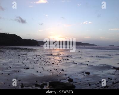 Tramonto riflette la sabbia sulla spiaggia di Pembrokeshire. Wales, Regno Unito Foto Stock